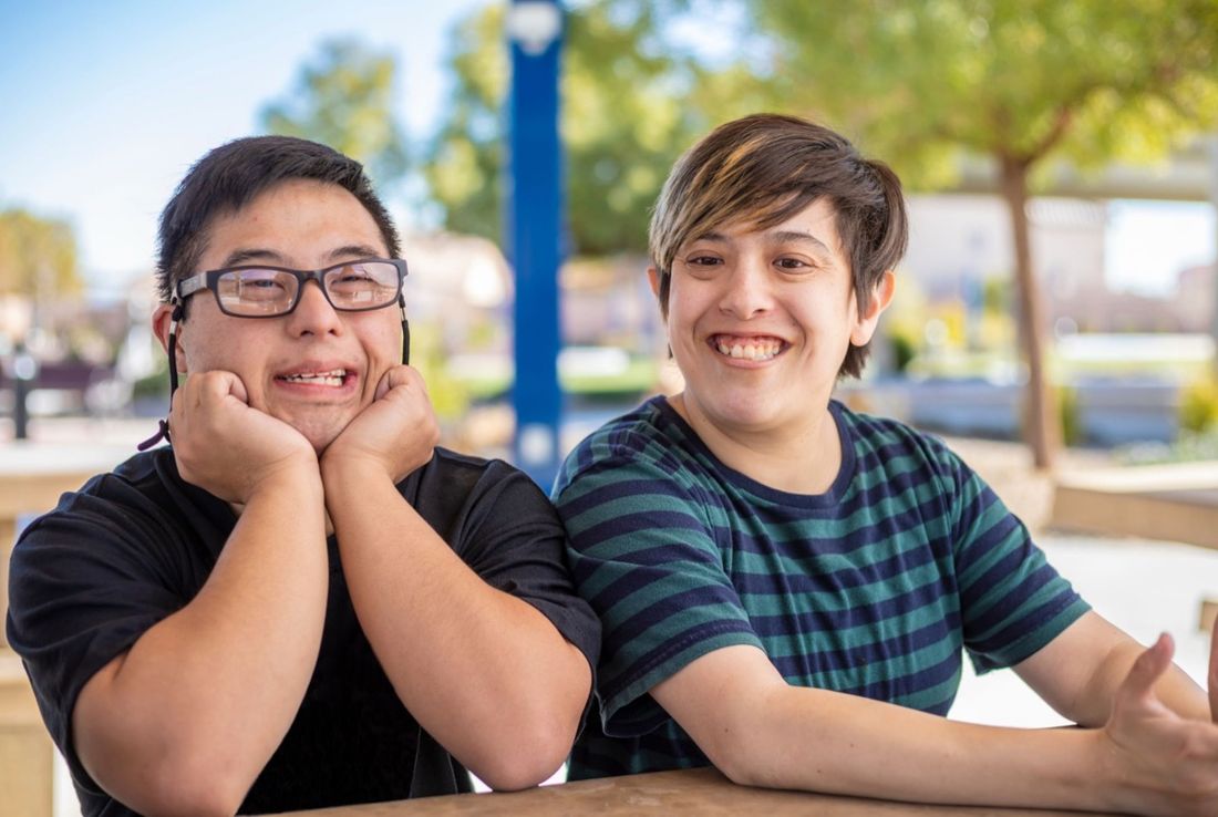Two participants smiling together outdoors