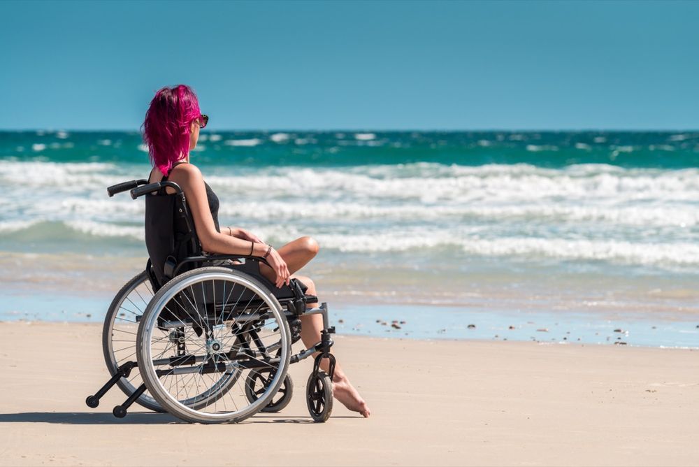 Support worker assisting a client at the beach